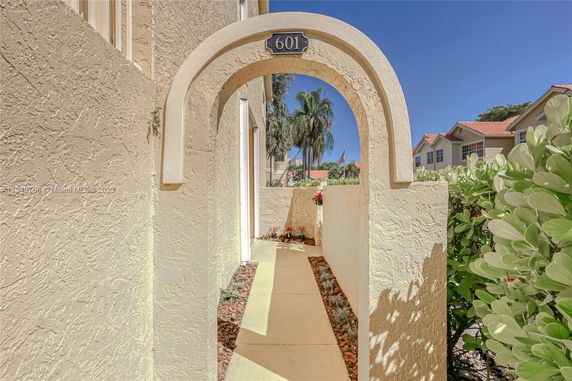Front view of a house with an arched entryway and textured walls.