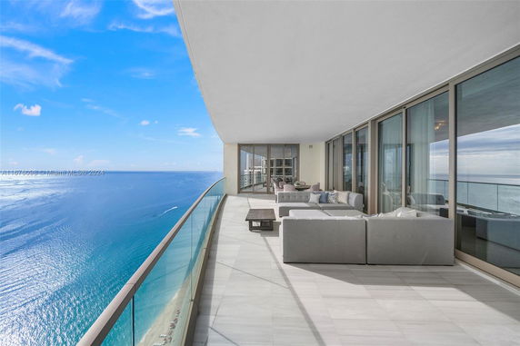 Balcony of a building with glass railing overlooking the ocean.