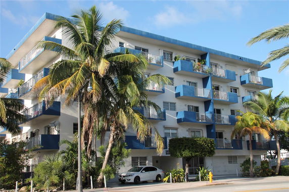 Front view of a multi-story apartment building with blue balcony accents.