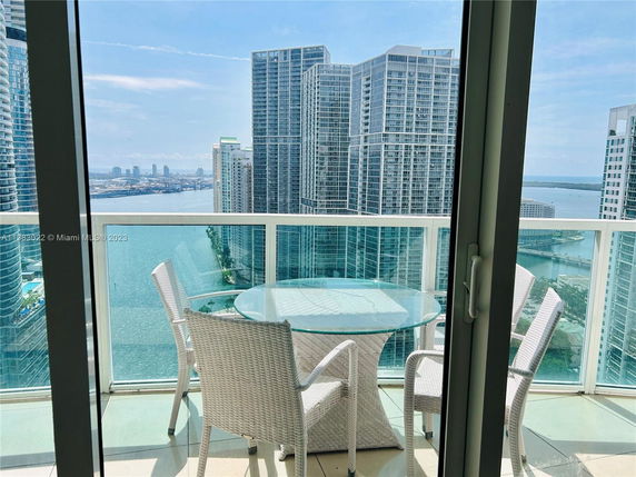 View from a high-rise building balcony overlooking a cityscape and water.