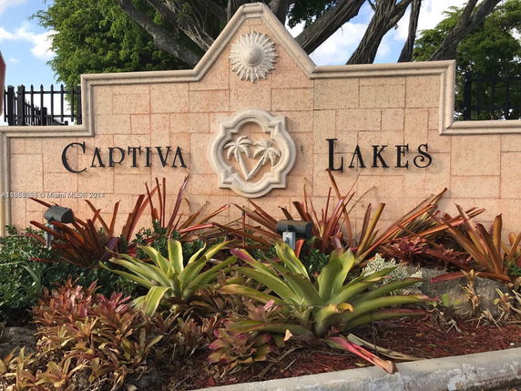 Decorative stone wall with 'Captiva Lakes' lettering and landscaping.