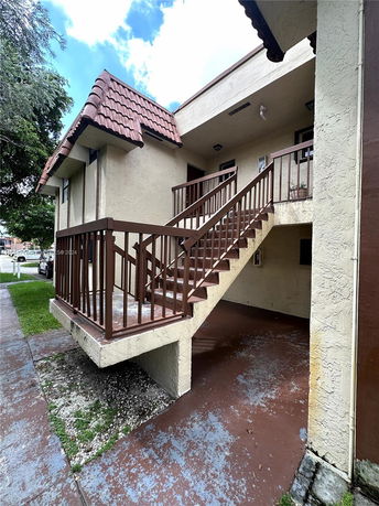 Front view of a building with a staircase leading to the second floor.