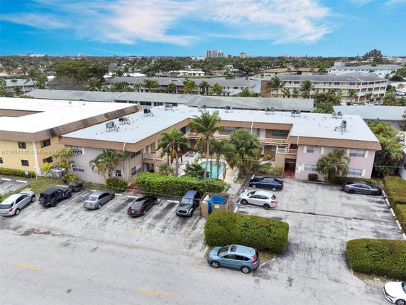 Aerial view of a two-story apartment building with parking spaces in front.