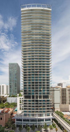 Front view of a high-rise building with multiple balconies and a modern architectural design.
