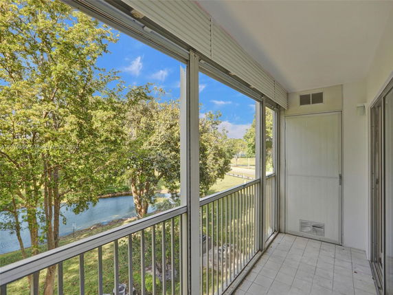 View from a balcony overlooking trees and a pond.