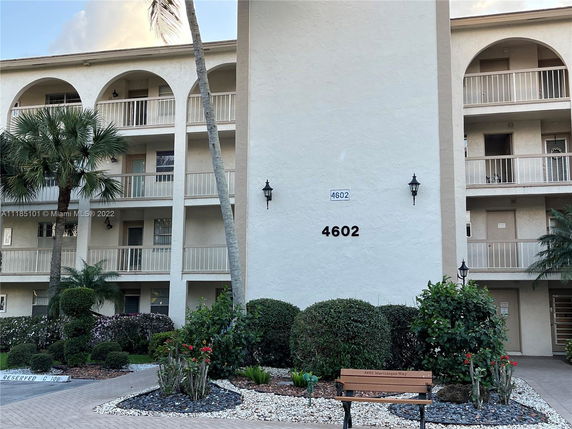 Front view of a multi-story residential building with balconies and arched features.
