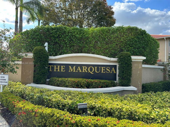 Front view of a residential entrance sign for 'The Marquesa' with landscaping.
