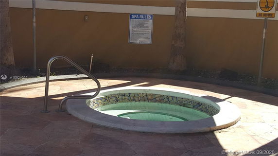 Outdoor hot tub with a metal handrail and tiled interior