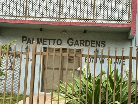Front view of a building with a balcony and metal fence.