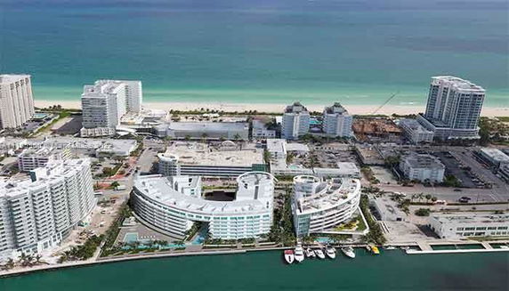 Aerial view of a coastal cityscape with multiple modern buildings near the ocean.