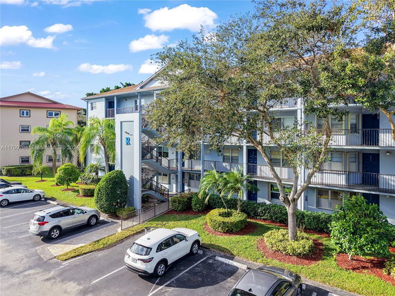 Outdoor view of a multi-story building with adjacent parking area.
