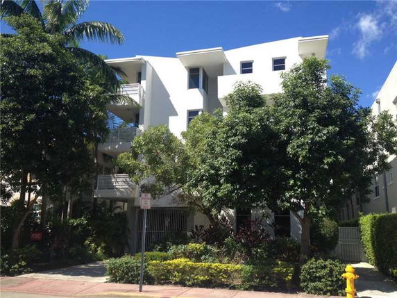 Front view of a multi-story apartment building with balconies.
