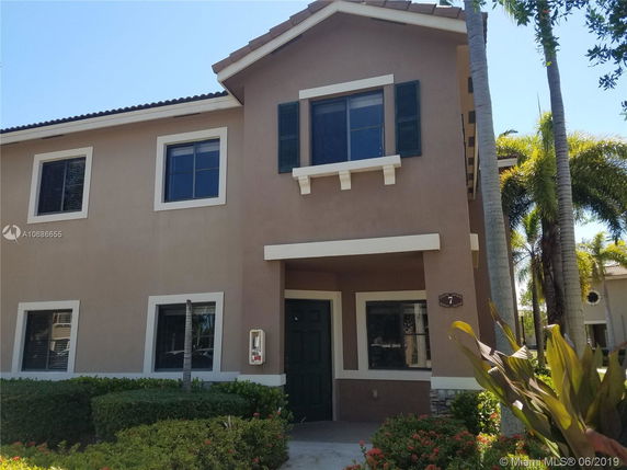 Front view of a two-story house with beige walls and white trim.