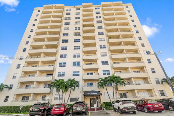 Front view of a multi-story apartment building with balconies.