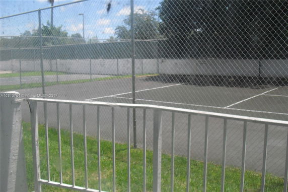 View of a fenced outdoor tennis court.