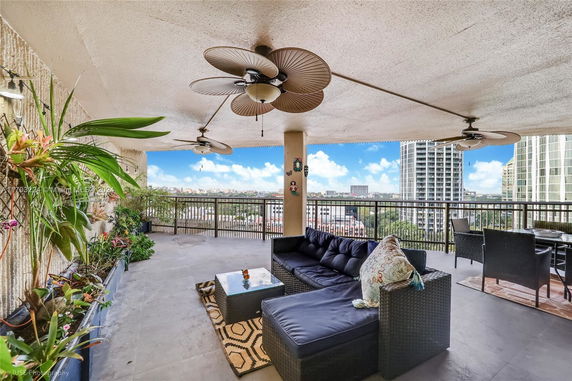 Panoramic view from a balcony with seating area and ceiling fans.