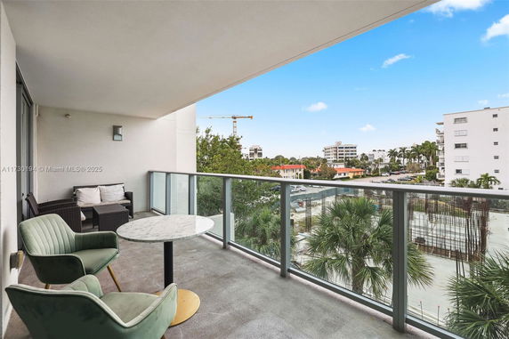 Balcony view with seating and surrounding residential buildings in the distance.