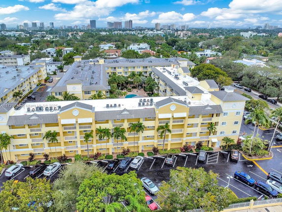 Aerial view of a multi-story residential building with a parking area in front.