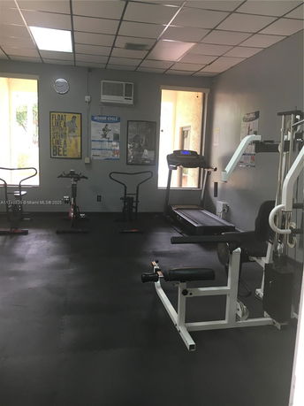 Indoor gym area with exercise equipment including treadmills and stationary bikes.