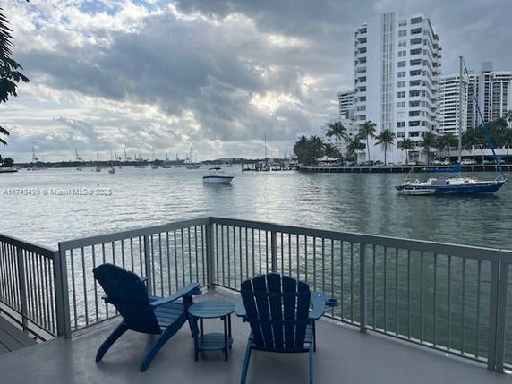 Panoramic view of water with boats and distant buildings.