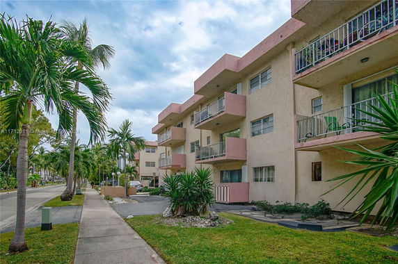 Front view of a multi-story apartment building with balconies.