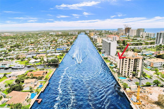 Panoramic aerial view of a riverside cityscape with buildings and a canal.
