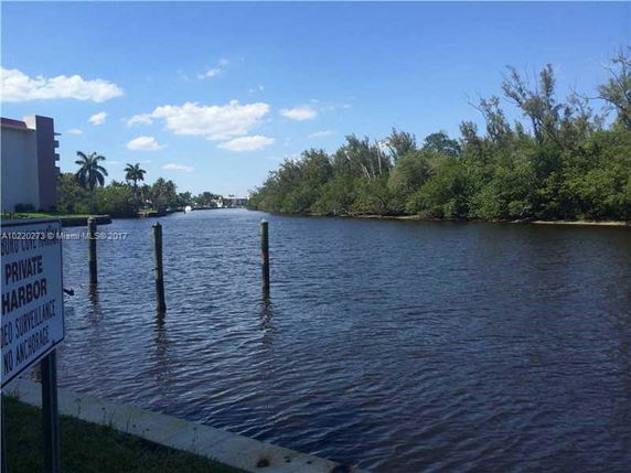 View of a waterway with greenery and a building on the left.