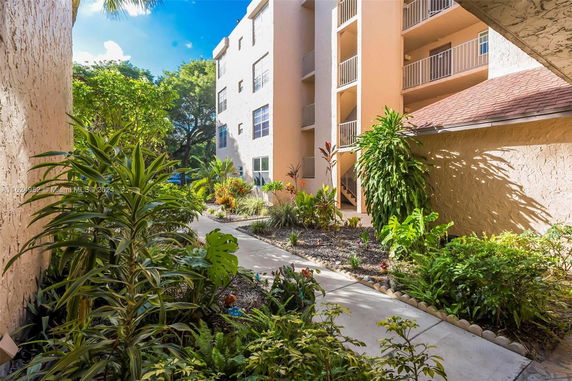 Garden path and exterior view of a multi-story building with balconies.