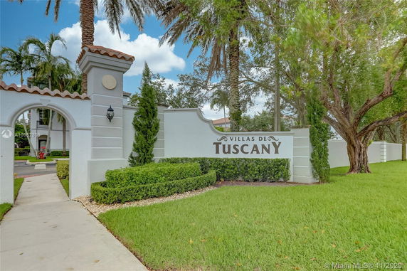 Entrance view of Villas de Tuscany featuring signage and surrounding greenery.