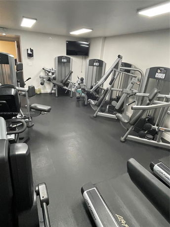 Indoor gym with exercise equipment, including treadmills and weight machines.