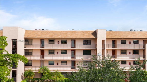 Front view of a multi-story apartment building with balconies.