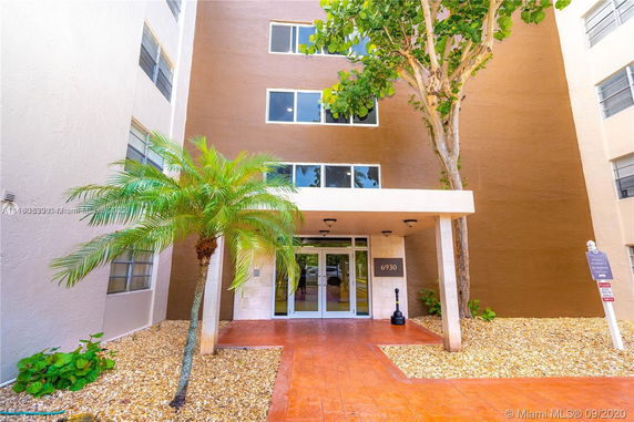 Front view of a building entrance with large windows and an overhang