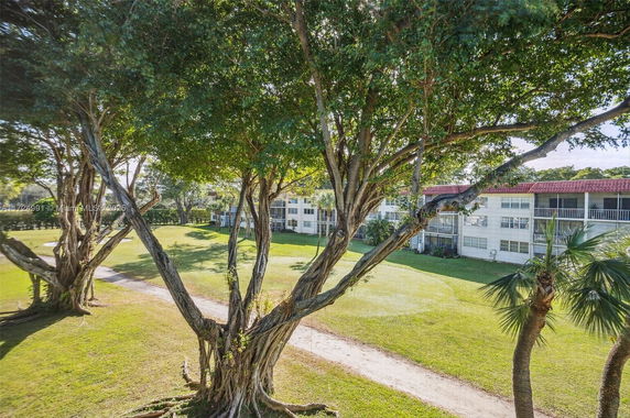 View of surrounding area with trees and apartment buildings in the background.