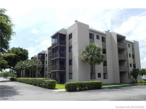 Front view of a multi-story apartment building with balconies.