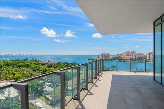 Panoramic view of the ocean and surrounding buildings from a balcony.