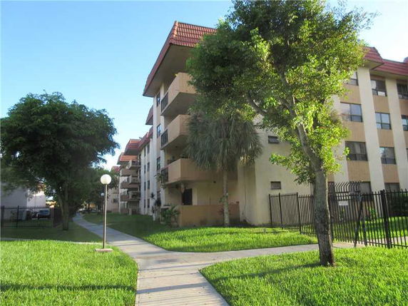 Front view of a multi-story apartment building with balconies.