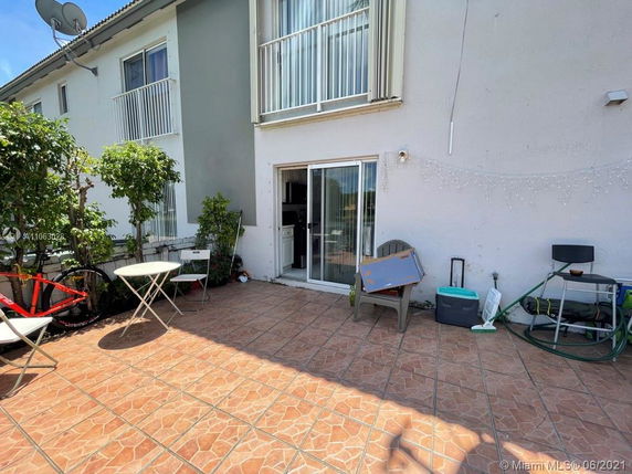 Backyard patio area with sliding glass door leading into a building.