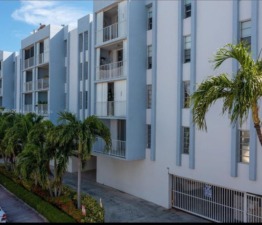 Front view of a multi-story apartment building with balconies.