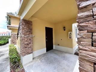 Front view of a covered entrance to a house with stone accents.
