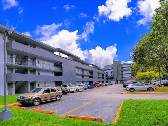Outdoor parking area in front of a multi-story building.