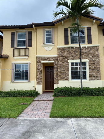 Front view of a two-story house with stone and yellow siding and brown shutters.