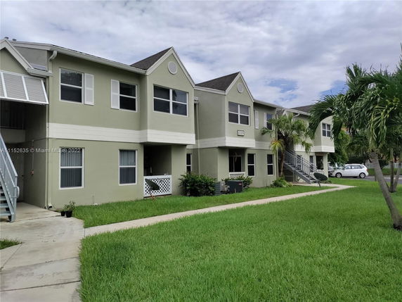 Front view of a two-story residential building with staircases leading to the upper level.