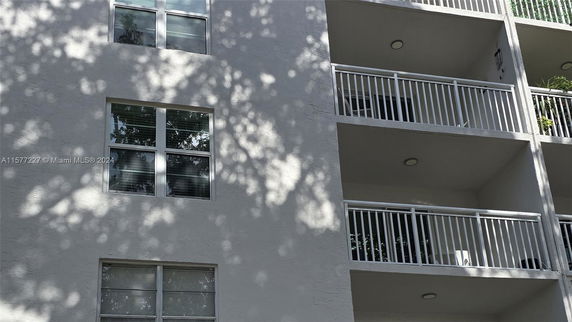 Front view of a multi-story building with balconies and windows.