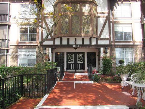 Front view of a building with decorative windows and a brick facade.