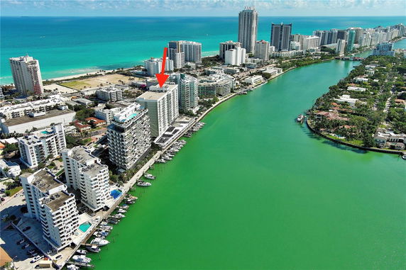 Panoramic view of coastal cityscape with tall buildings near a waterway.