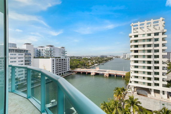 Panoramic view of a river with modern buildings and a bridge.