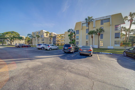 Outdoor parking area in front of an apartment building.