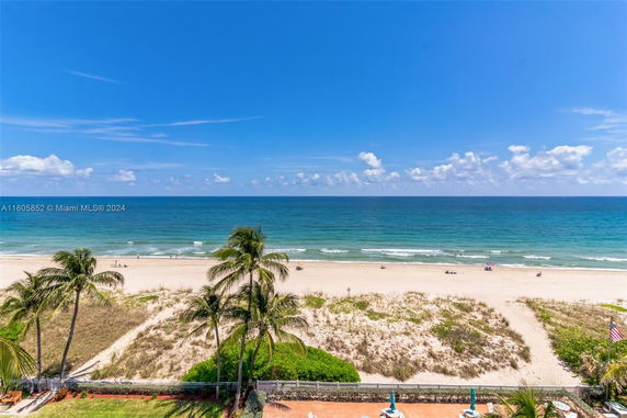 Panoramic view of a beach with clear blue sky and ocean.