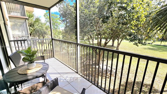 View from a balcony showing trees and grass outside.