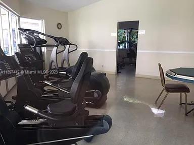 Room with exercise equipment and a table with chairs.